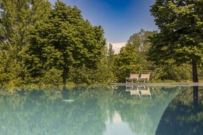 Een seizoensgebonden buitenzwembad en ligstoelen