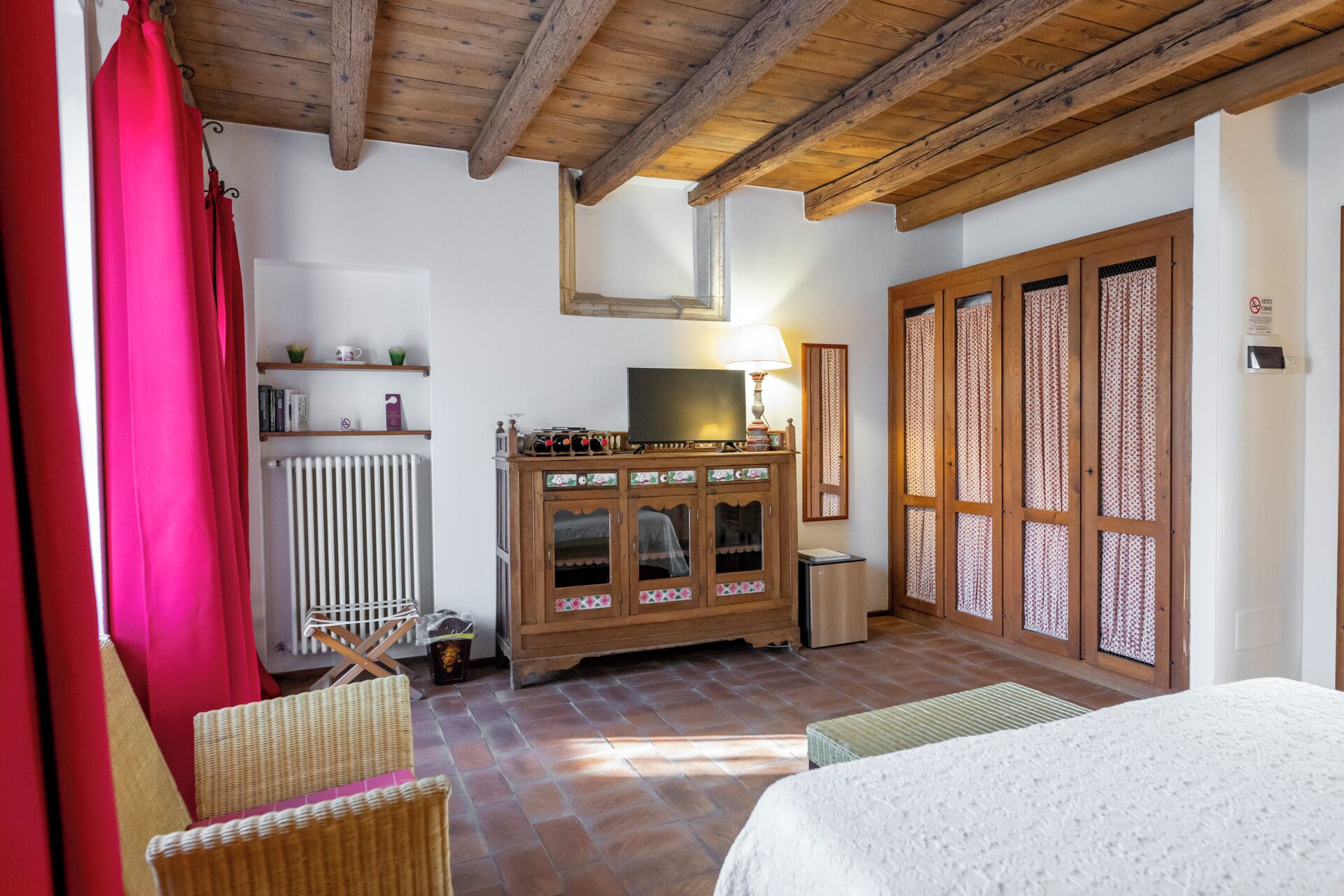 A cozy room with a wooden cabinet, a television, and a radiator.