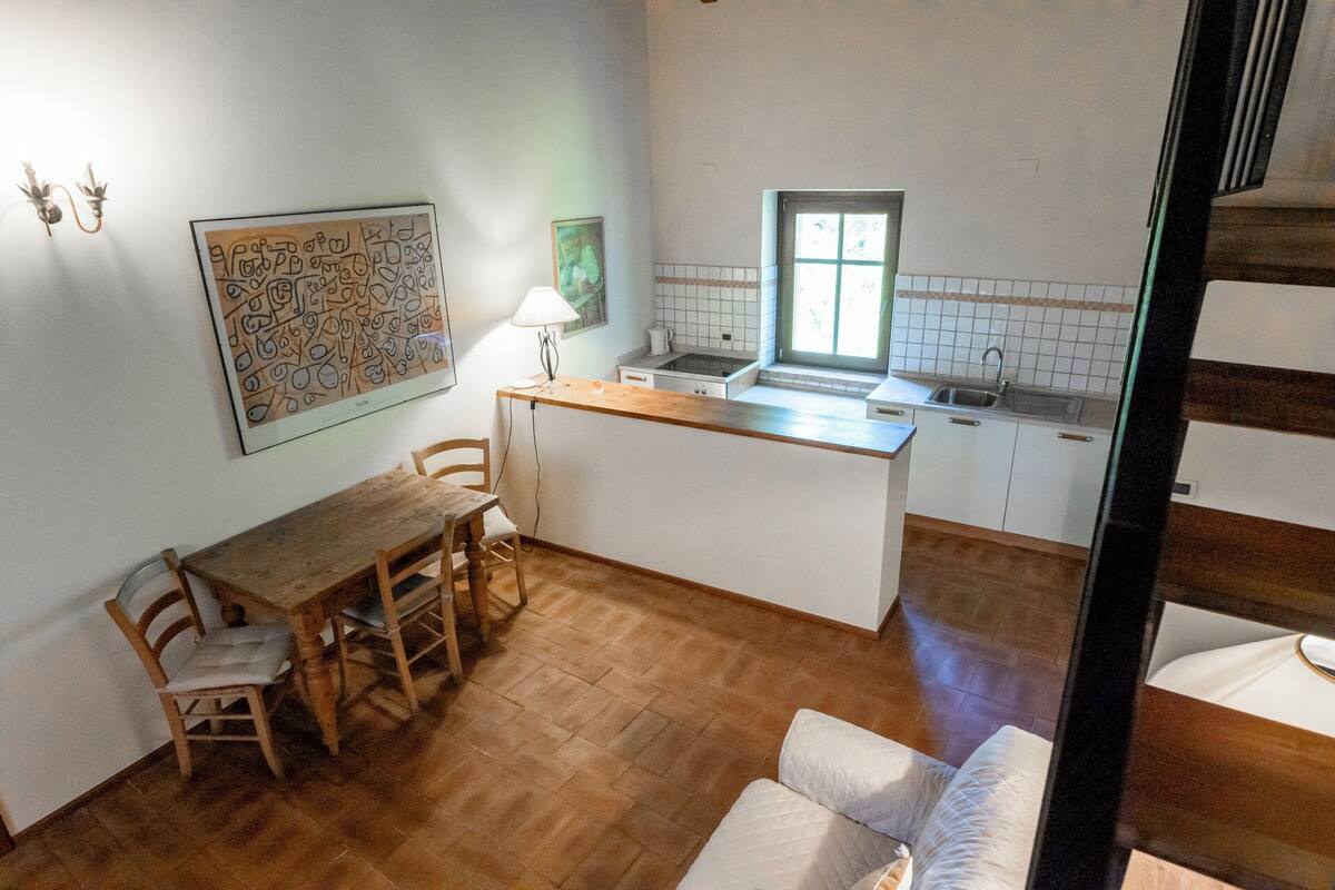 Eine kompakte Küche mit Essbereich, einer kleinen Kochinsel und einem Fenster.