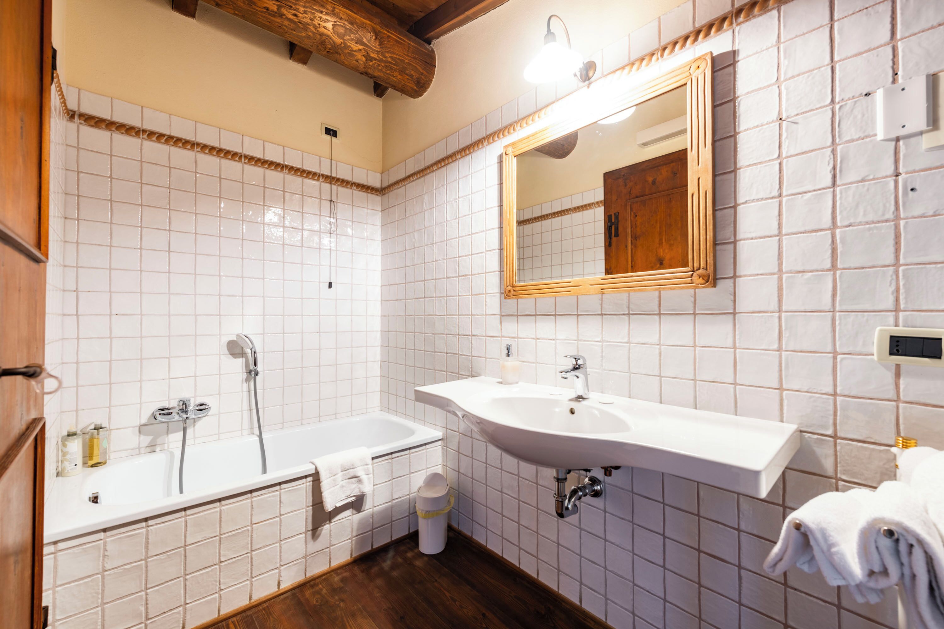 A bathroom with a bathtub, a sink, and a mirror.