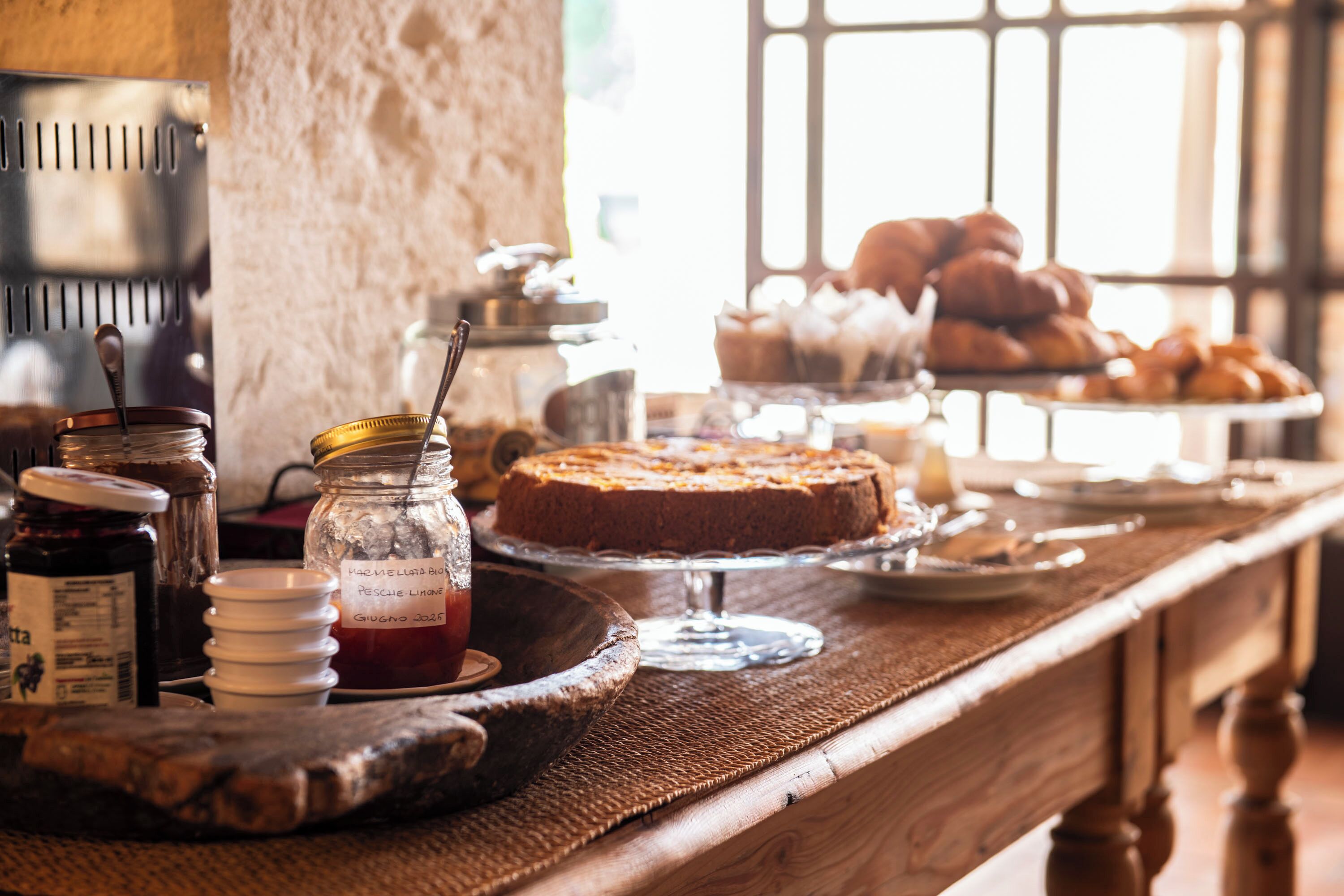 A breakfast buffet with various food items and condiments on a wooden table.