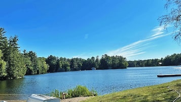 En sjö med båtar förtöjda vid stranden, omgiven av träd.