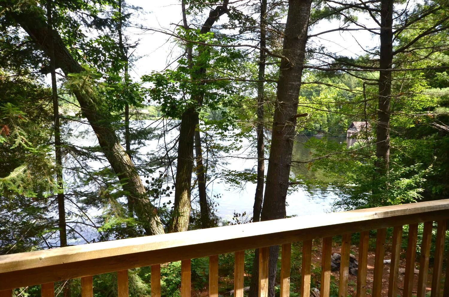 Una terraza de madera con vistas a un bosque y un lago.