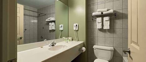 Une salle de bain avec un lavabo, un miroir et des toilettes.