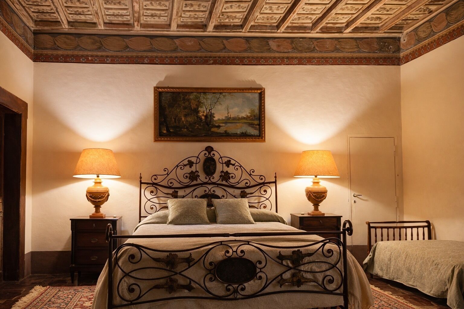 Un dormitorio con una cama, dos mesitas de noche con lámparas, una puerta y un techo con un diseño decorativo.