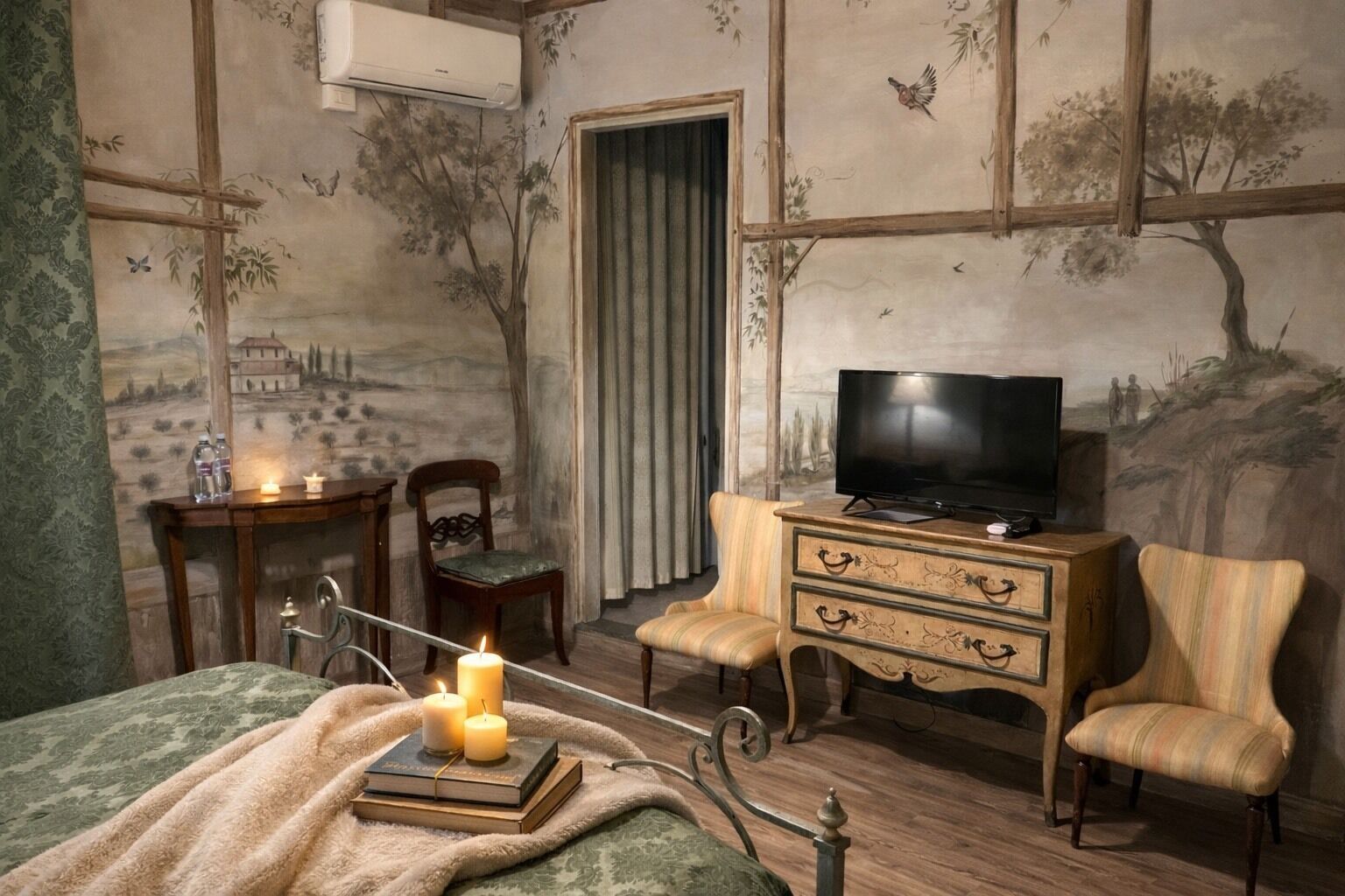 Ein Schlafzimmer mit einem Bett, einer Holzkommode, einem Fernseher, einem Sessel, einem Schreibtisch und einer Wand mit Wandgemälde.
