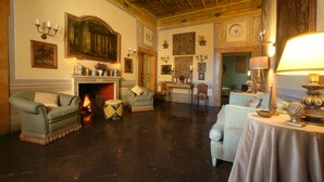 Amplia sala de estar con chimenea, asientos cómodos y comedor.