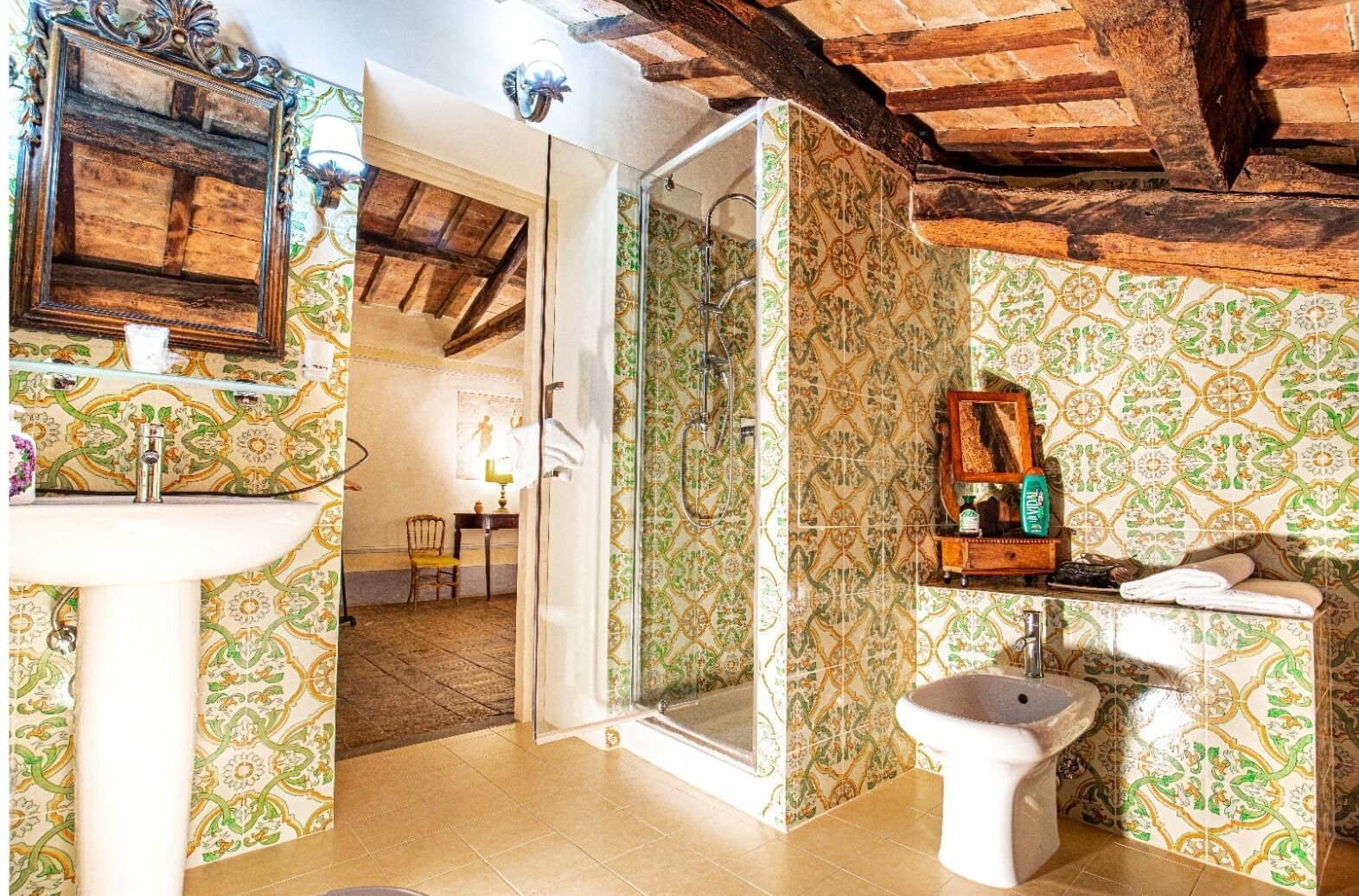 A bathroom with a shower, sink, toilet, and a mirror.