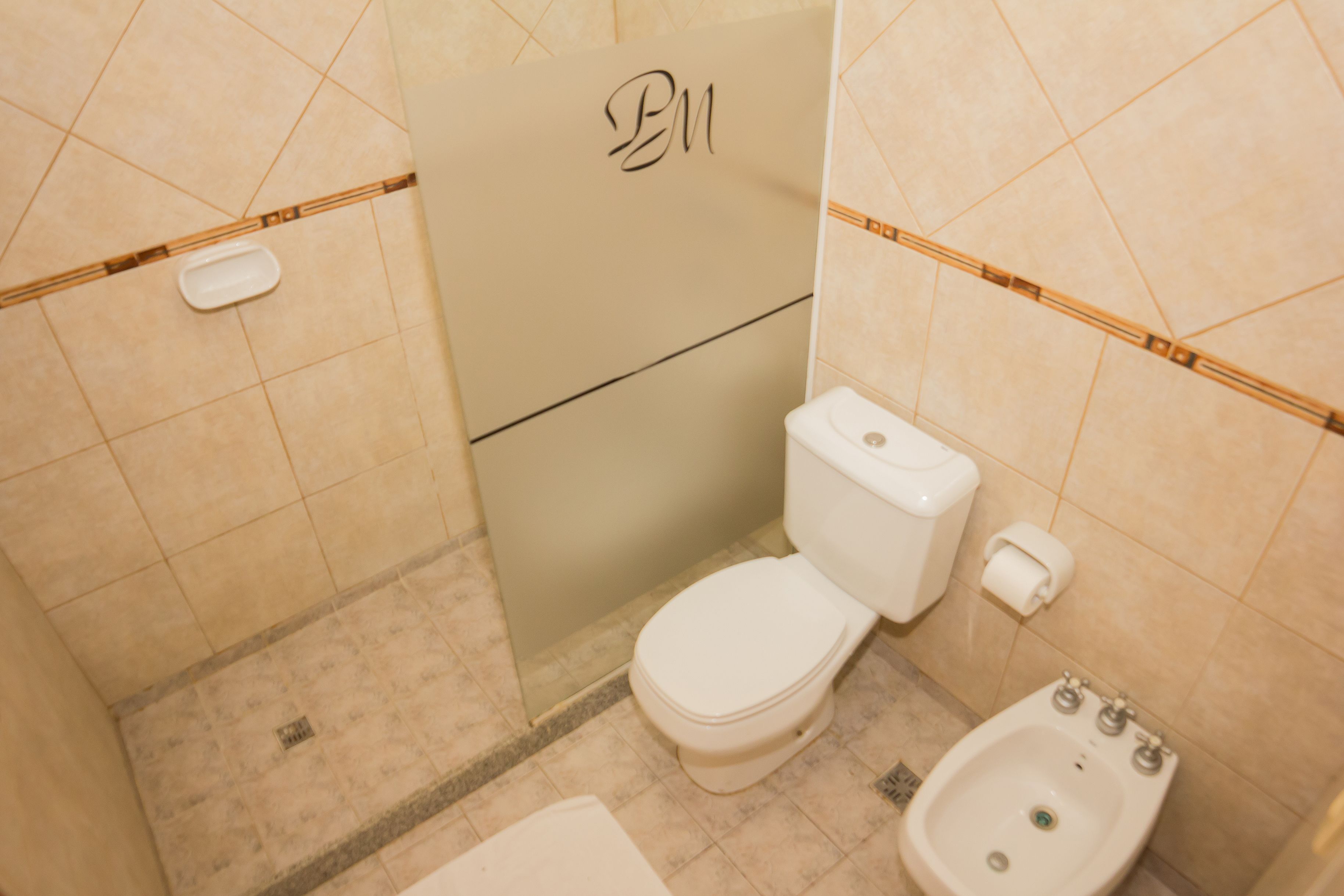 Ein Badezimmer mit Toilette, Bidet und Handtuchhalter.