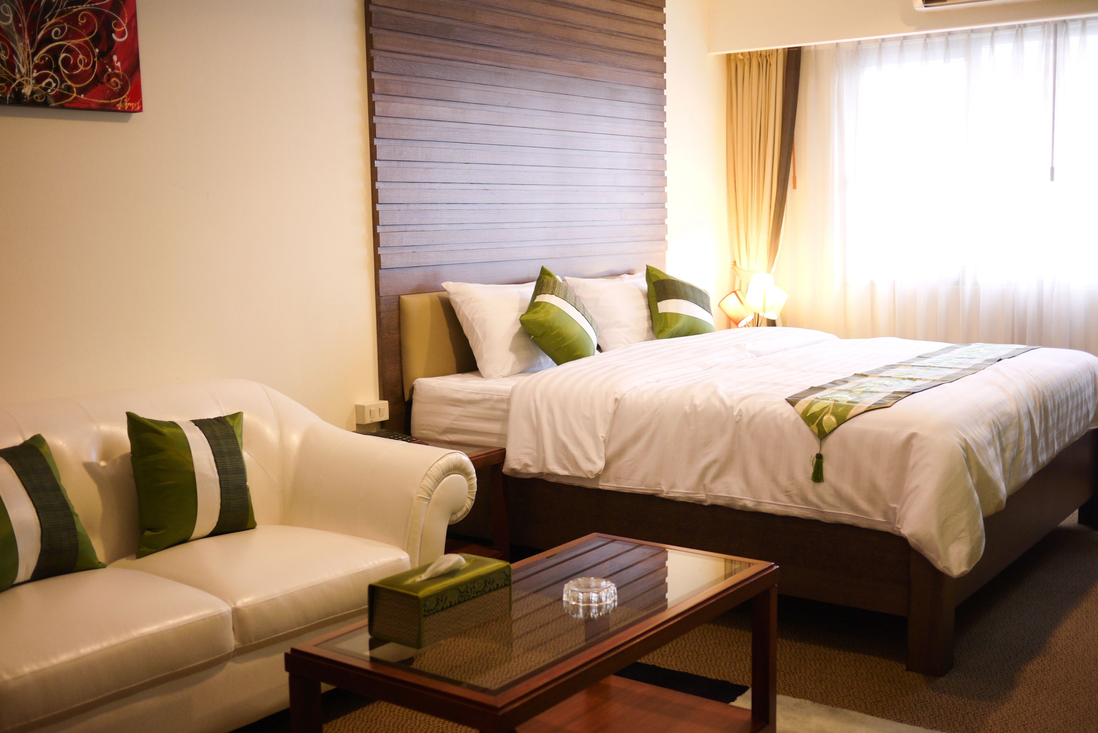 A hotel room with a bed, a sofa, and a coffee table.