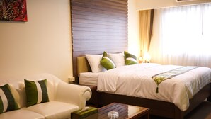 A hotel room with a bed, a sofa, and a coffee table. - Triple 8 Inn Bangkok (Bangkok)