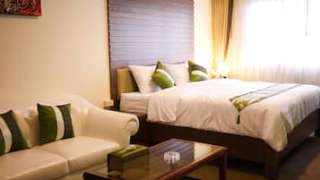 A hotel room with a bed, a sofa, and a coffee table.