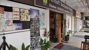 The exterior of Fernloft Backpacker Hostel in Chinatown with a wall displaying various travel posters and maps. - Fernloft Chinatown - Hostel (Singapore)