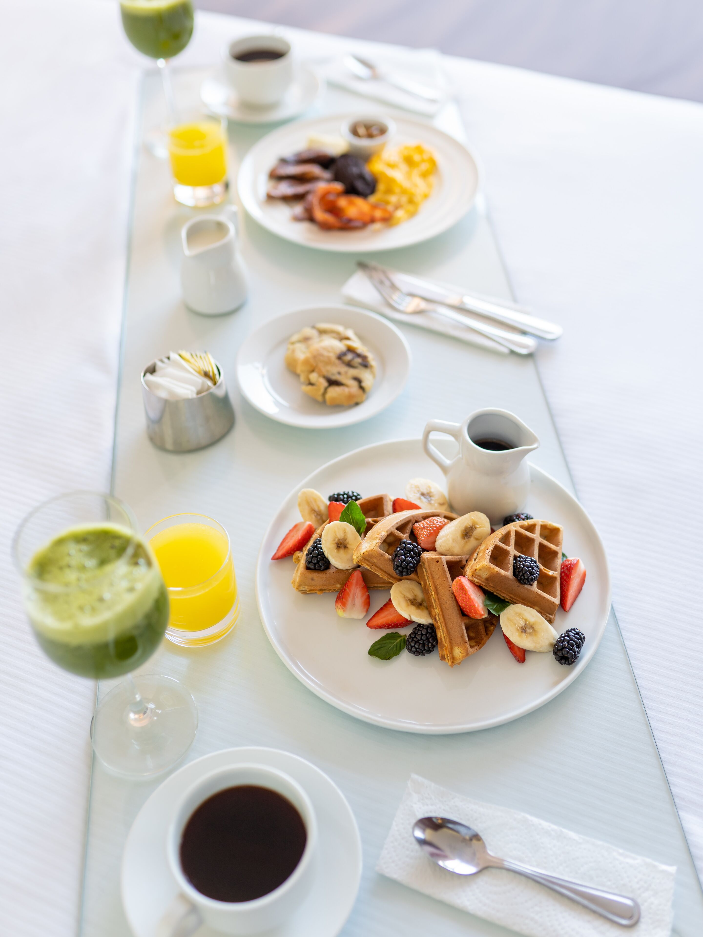 A breakfast buffet with various dishes and beverages.