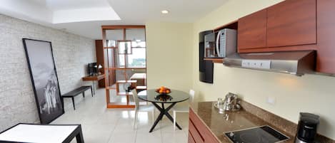 A modern kitchen with a dining area, featuring a granite countertop, stainless steel appliances, and wooden cabinets.