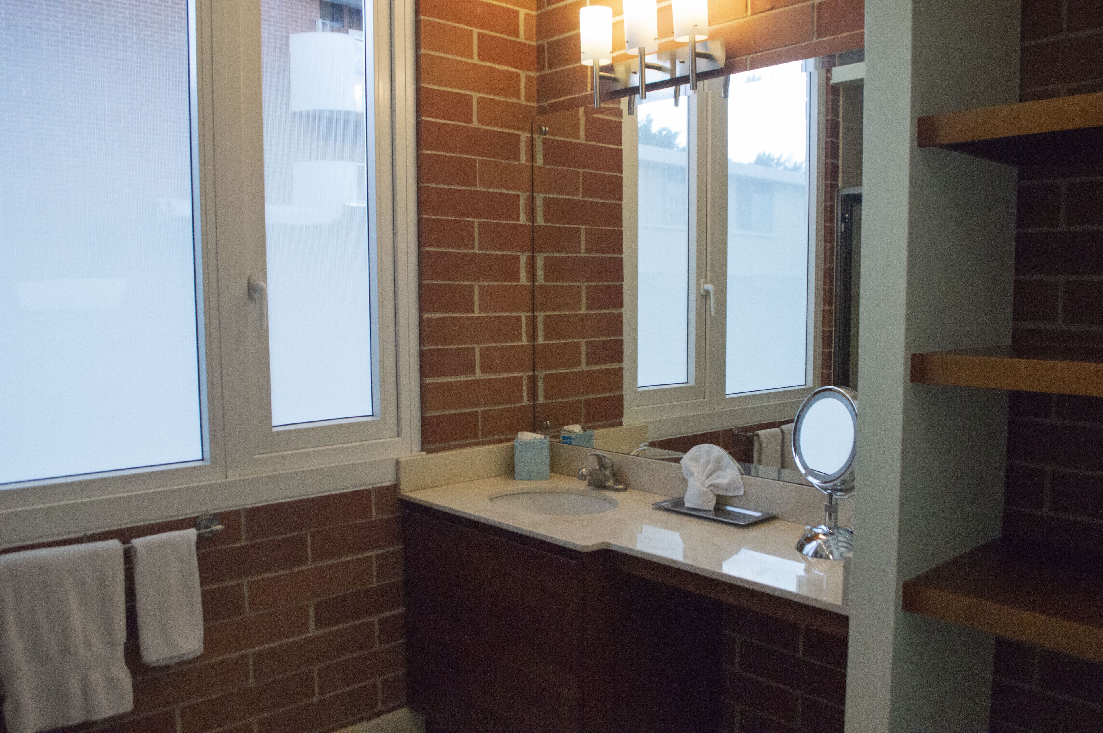 A bathroom with a sink, mirror, and towel rack.