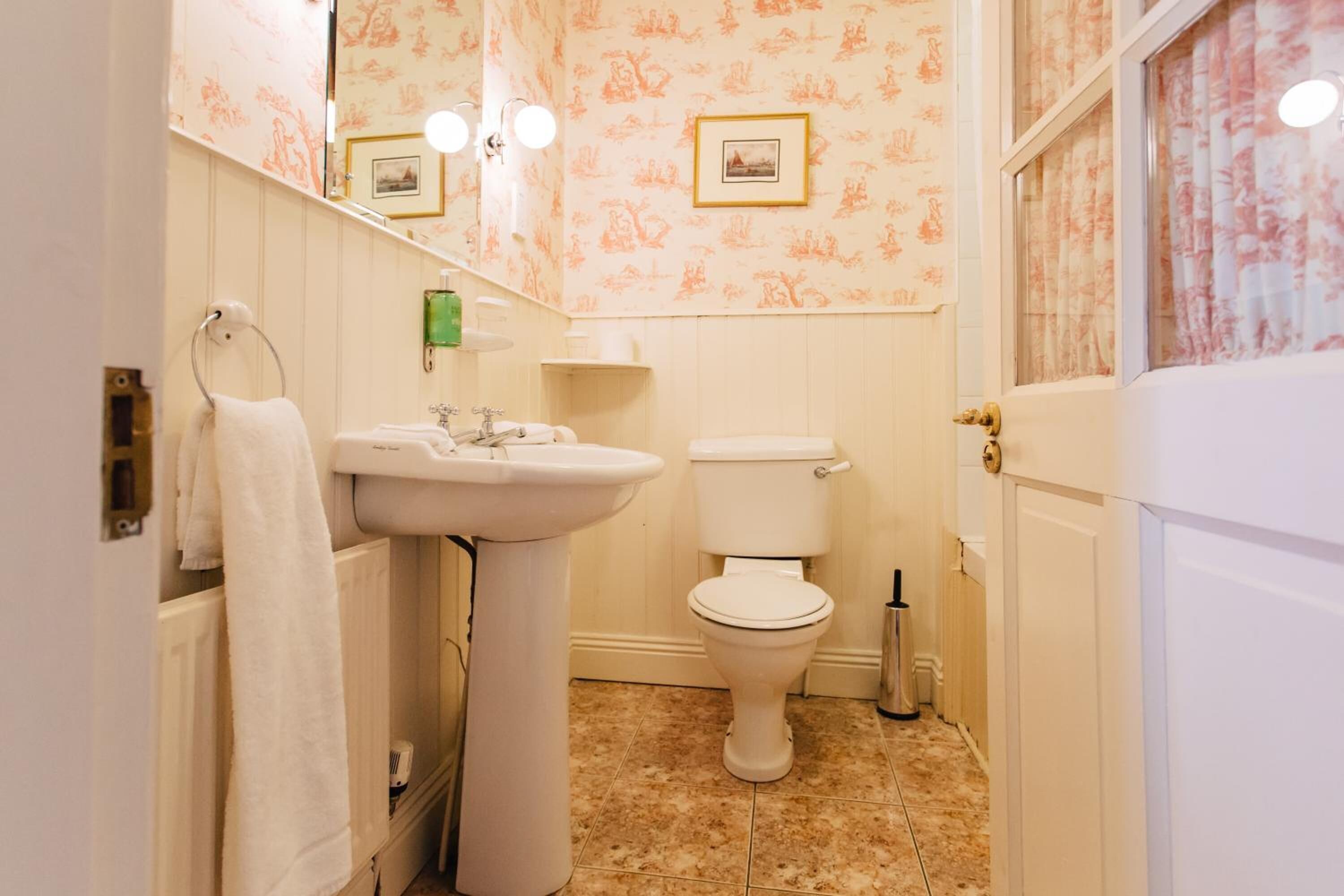 Ein Badezimmer mit Waschbecken, Toilette und Handtuchhalter.