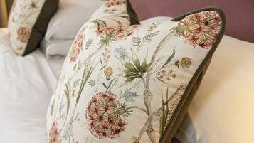 A bed with floral-patterned pillows and a headboard.