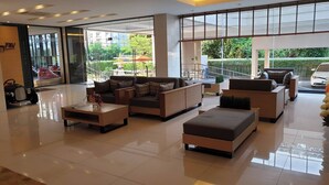 A spacious lobby with a modern sofa set, a coffee table, and a seating area with a view of the outdoors. - Parinda Hotel (Bangkok)