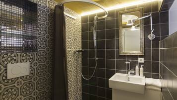 Une salle de bain avec des toilettes, un lavabo et une douche.