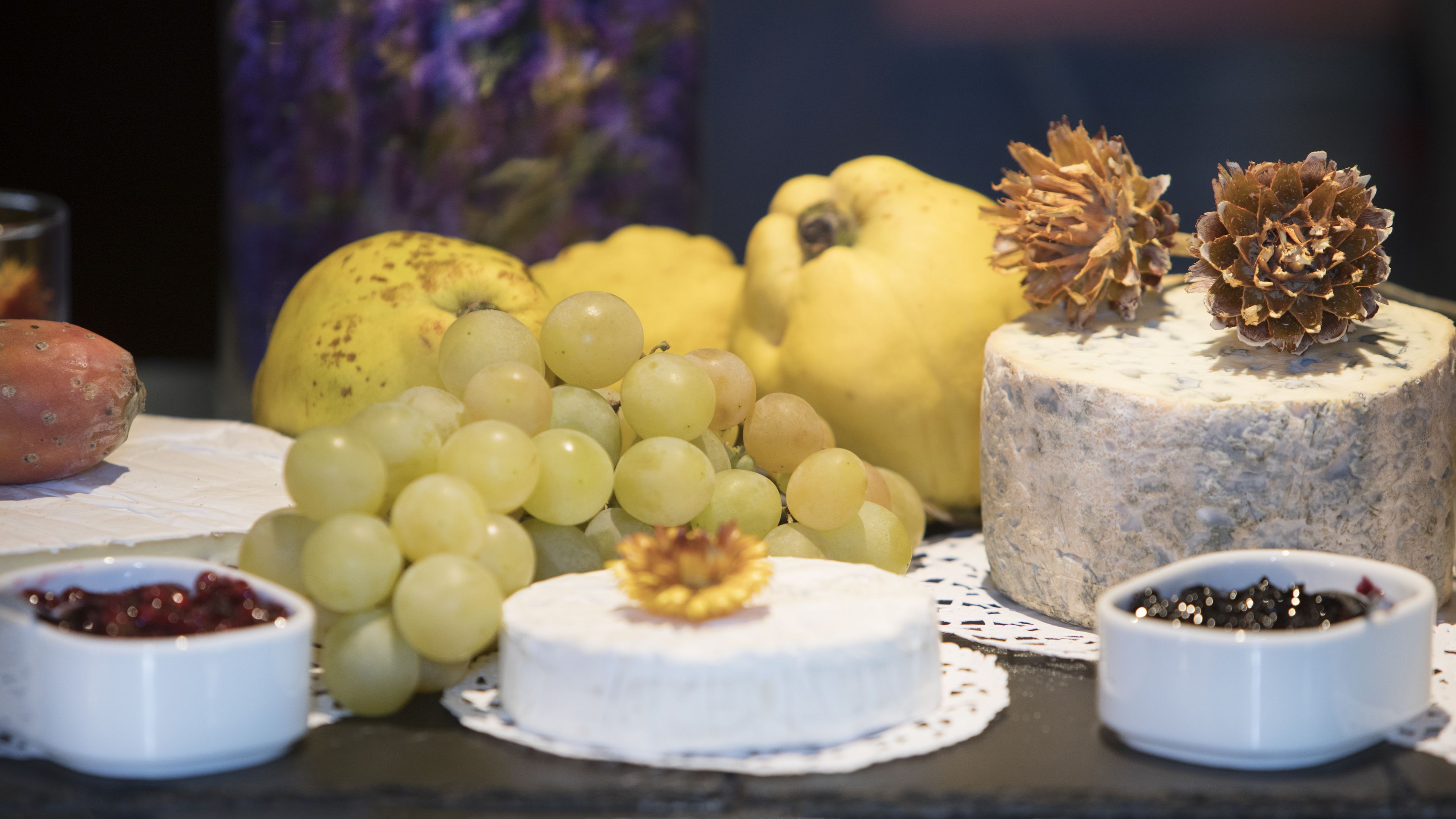 Tagliere con diversi formaggi, frutta e noci.
