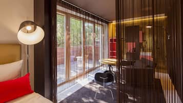 Una habitación de hotel moderna con una cama grande, un escritorio y vistas al exterior.