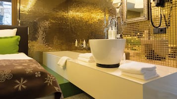 Ett hotellbadrum med en stor spegel, ett handfat och ett badkar.