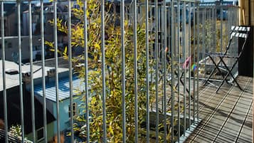 A metal railing with a view of buildings and mountains in the background.