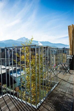 A metal railing with a view of buildings and mountains in the background. - NALA individuellhotel (Innsbruck)