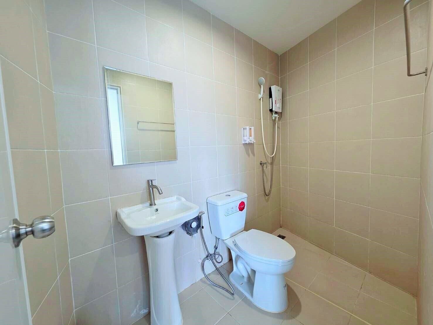 A small bathroom with a sink, toilet, and shower.