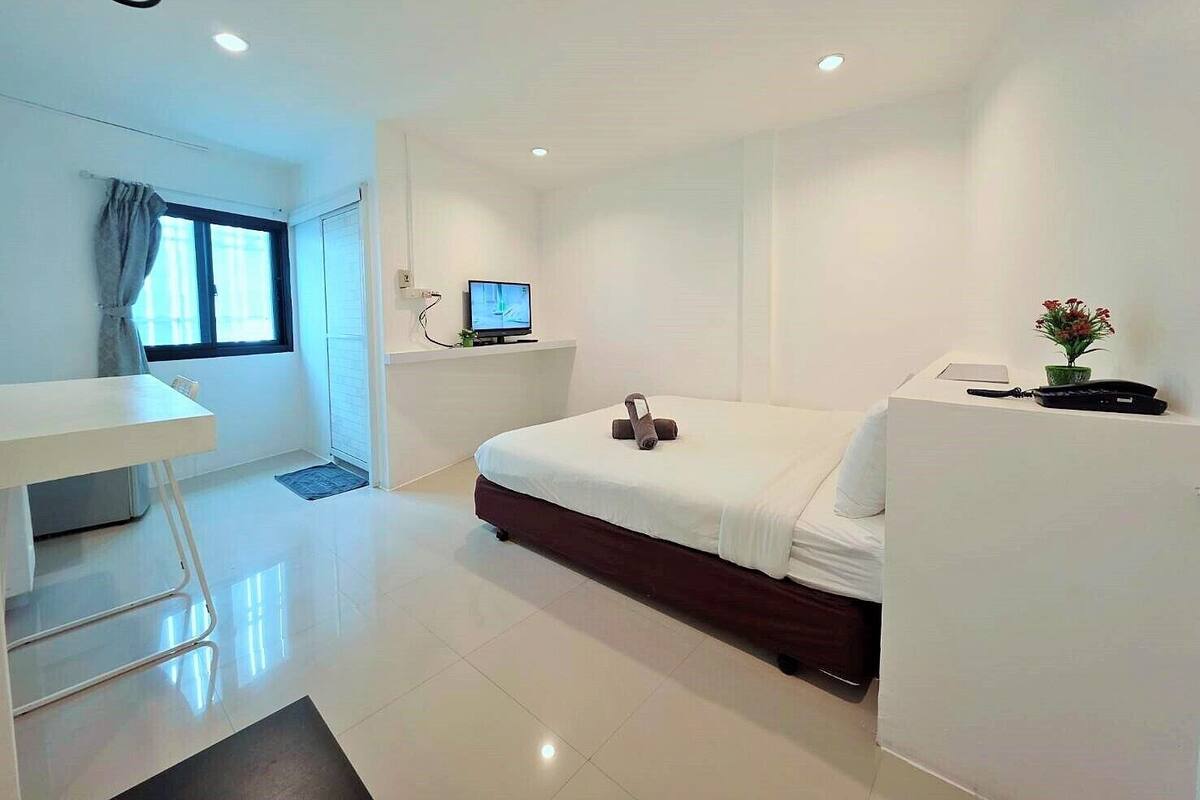 Une chambre d’hôtel moderne équipée d’un lit, d’un bureau et d’une télévision.