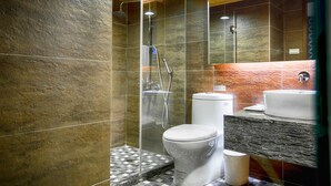 Un baño moderno con ducha, inodoro y lavamanos.