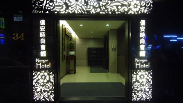 La entrada a un hotel de diseño moderno, con señalización iluminada y un interior acogedor.