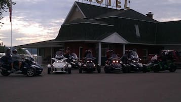 Un motel avec une grande enseigne, plusieurs motos garées devant et un mât sur lequel flotte un drapeau.