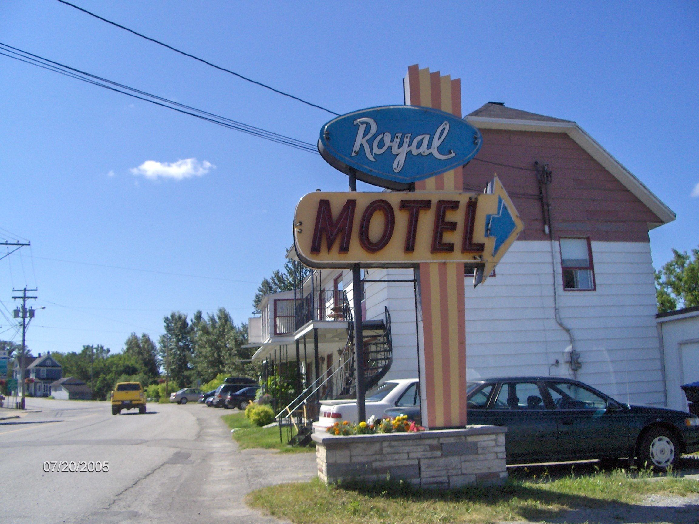 A motel sign with a directional arrow and the word "Royal" above it.