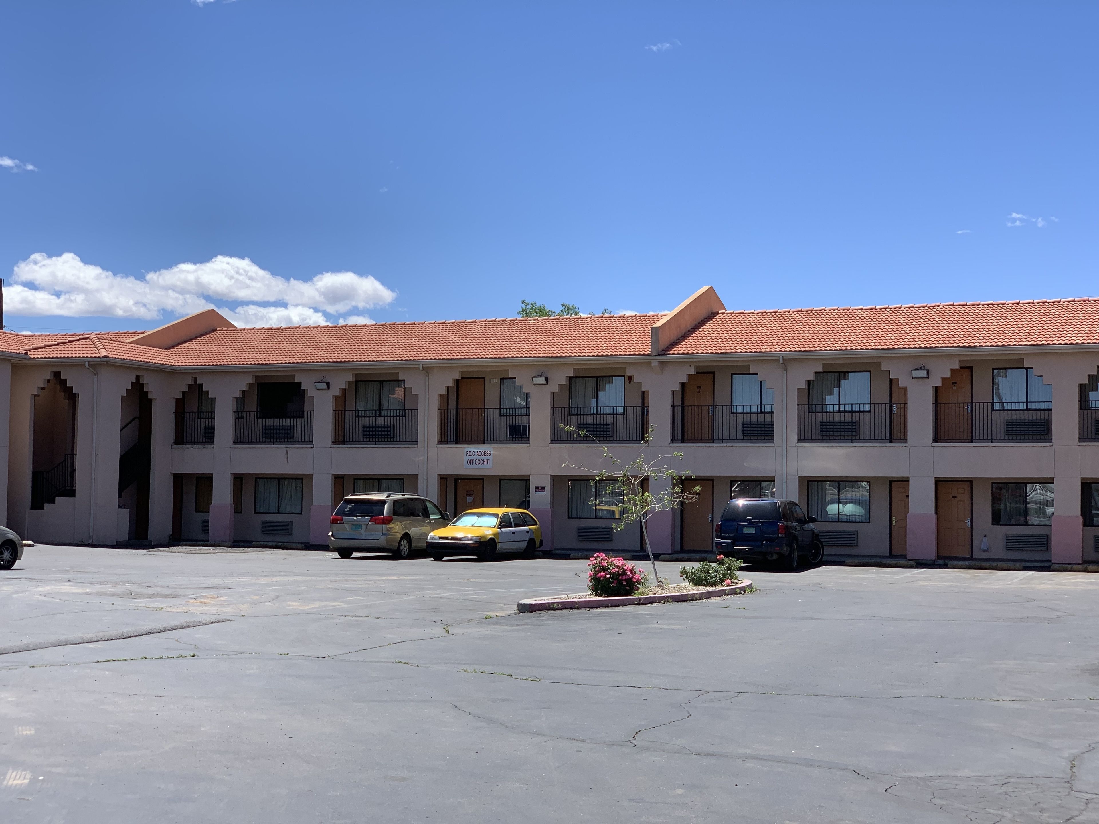 Motel de diverses plantes amb teulada vermella i un pati central.