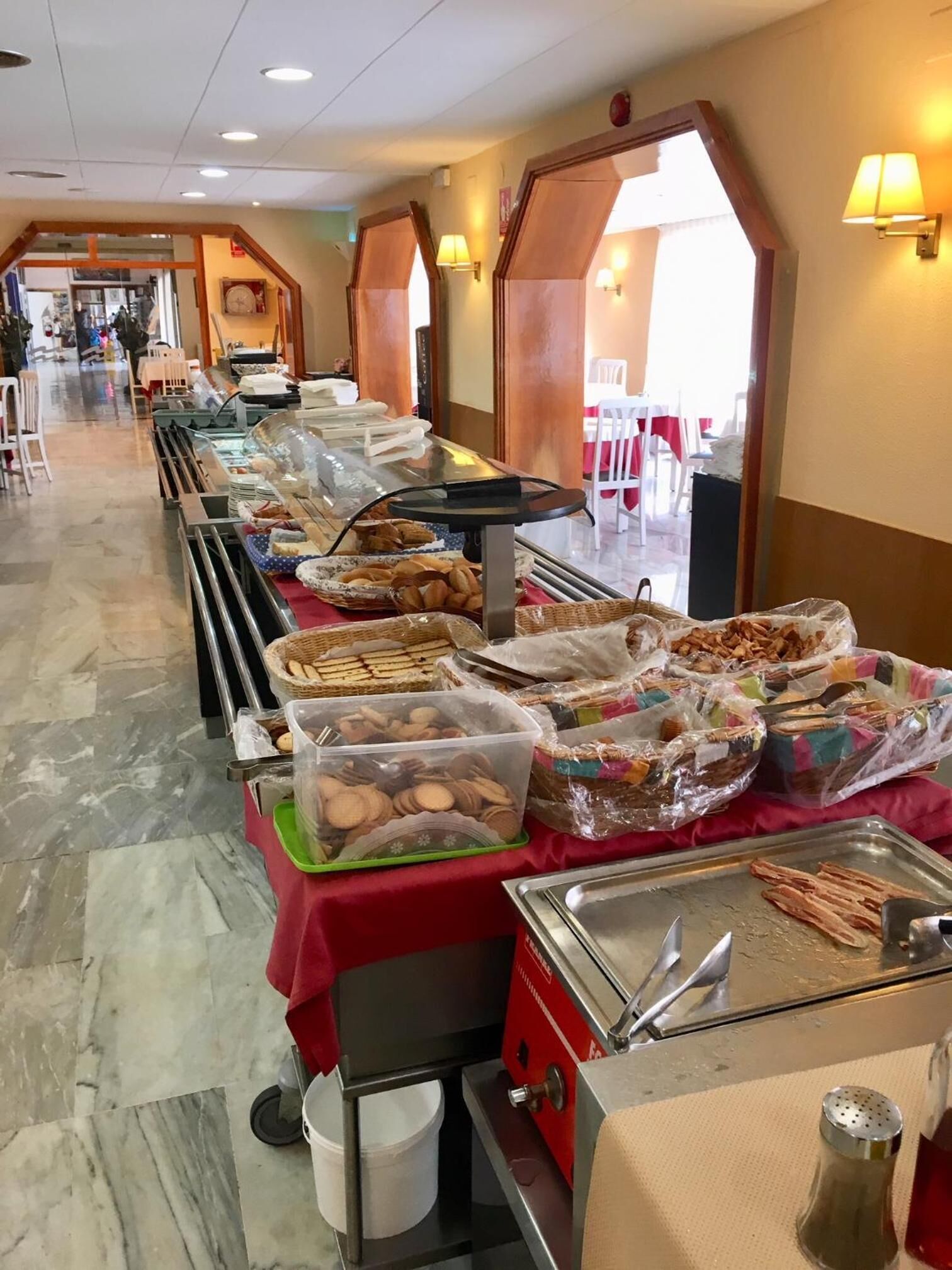 A buffet setup with various food items and a self-service station.