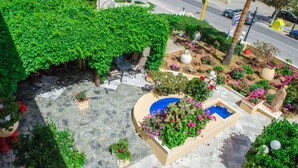 A rooftop garden with a seating area, a swimming pool, and various plants and flowers. - Alkion Hotel (Chania)
