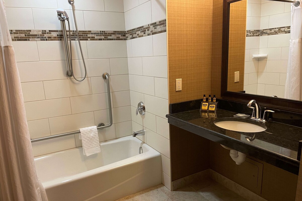 A modern bathroom with a bathtub, a shower, and a sink.