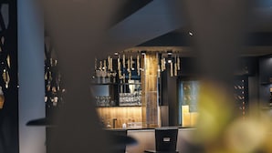 Un espace bar avec des luminaires suspendus, un comptoir et des tabourets de bar.