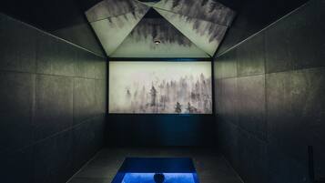 Relax in a serene bathroom with a bathtub and geometric-patterned walls featuring a nature-inspired mural.