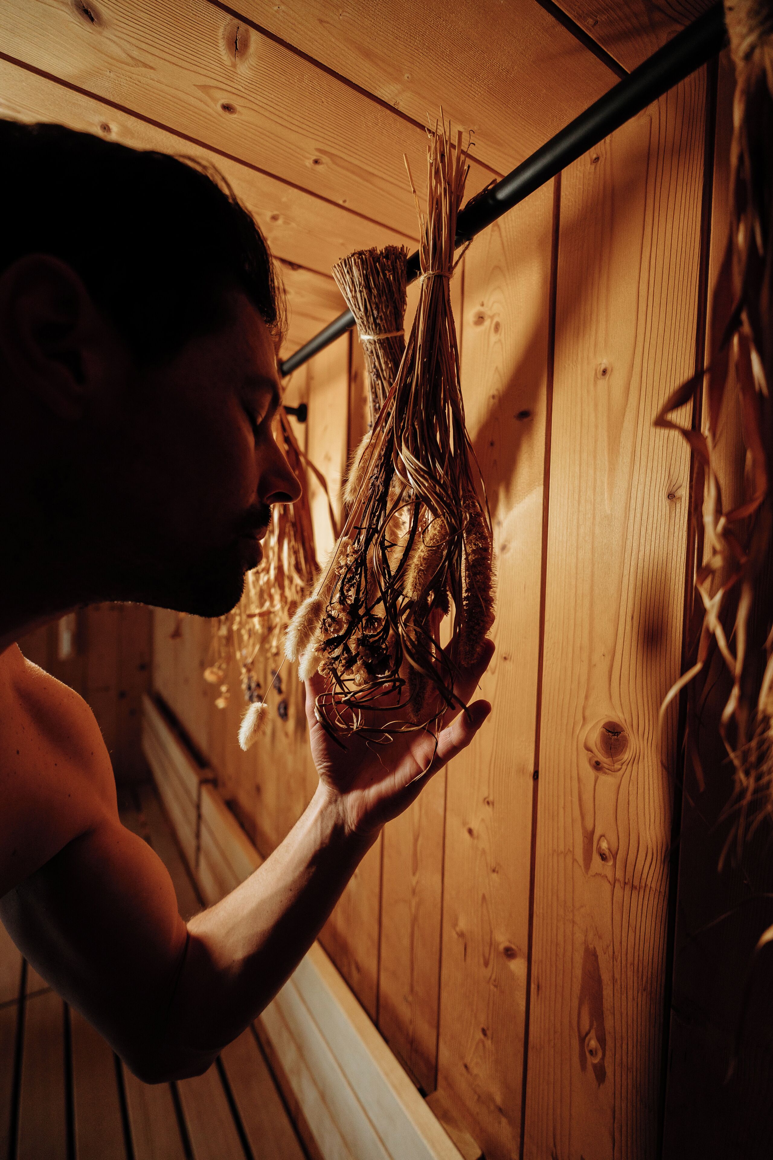 A person holding a bundle of dried plants.