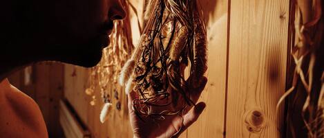 A person holding a bundle of dried plants.