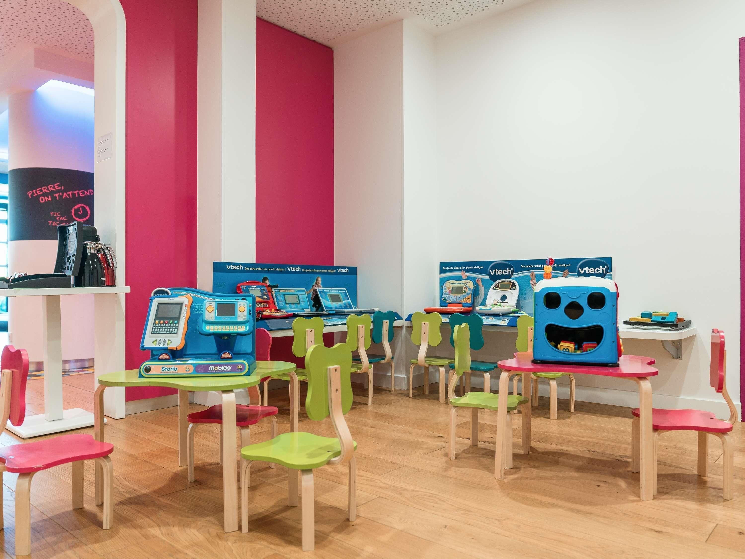 A children's learning area with educational stations and colorful chairs.