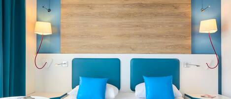 Una habitación de hotel con una cama, dos mesitas de noche, una mesa y techo de madera.