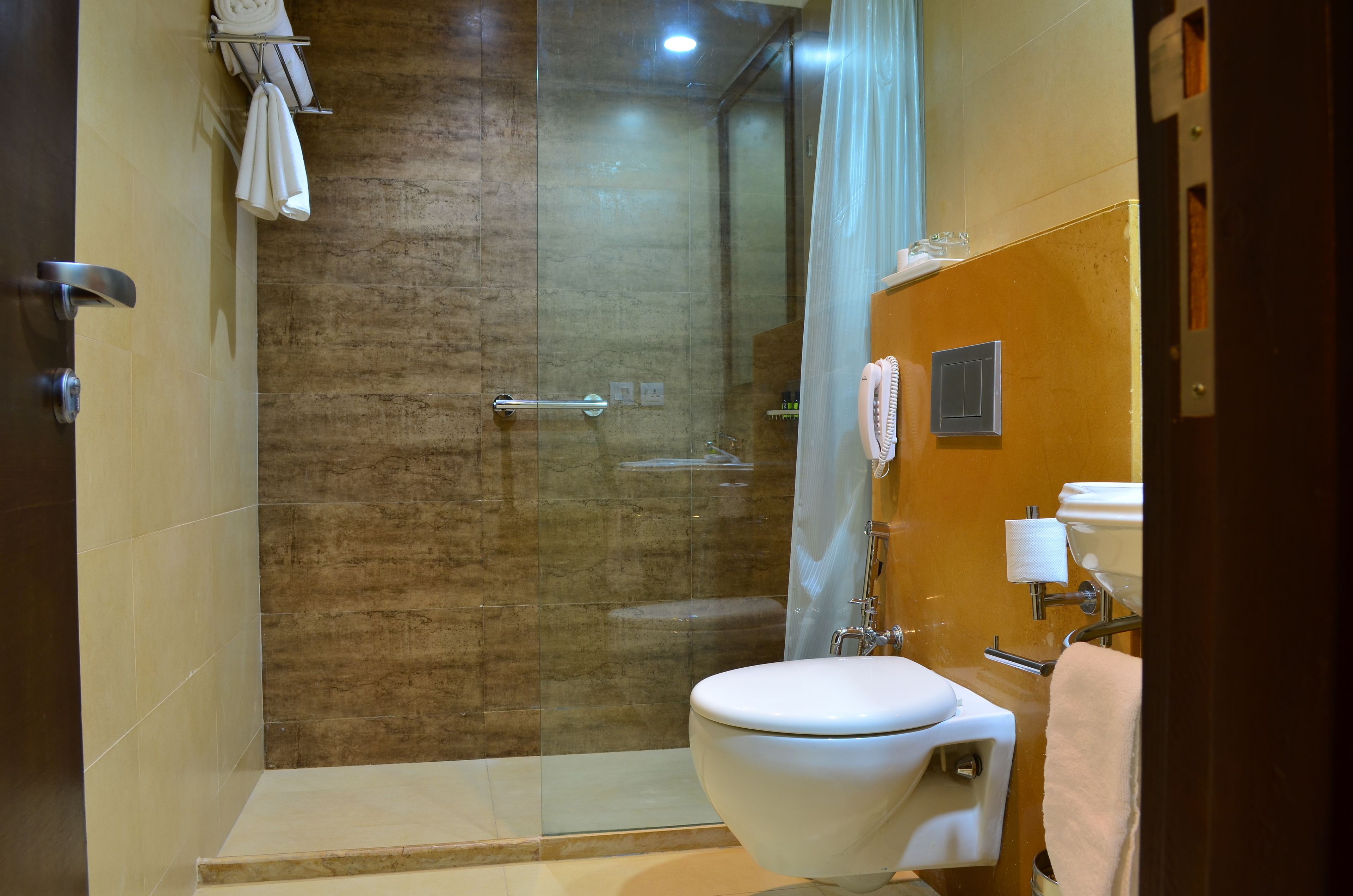 Un baño moderno con cabina de ducha de vidrio, inodoro y lavamanos.