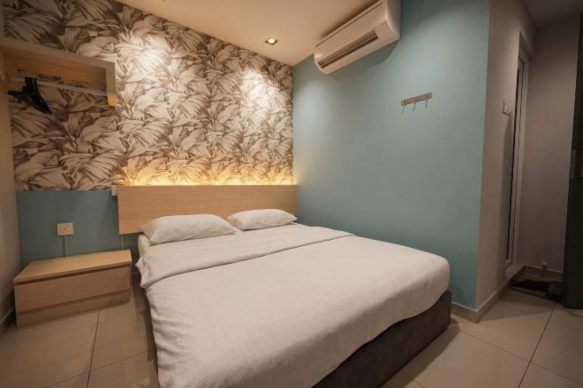 Une chambre à coucher comprenant un lit, une table de chevet, une étagère fixée au mur et un appareil de climatisation.