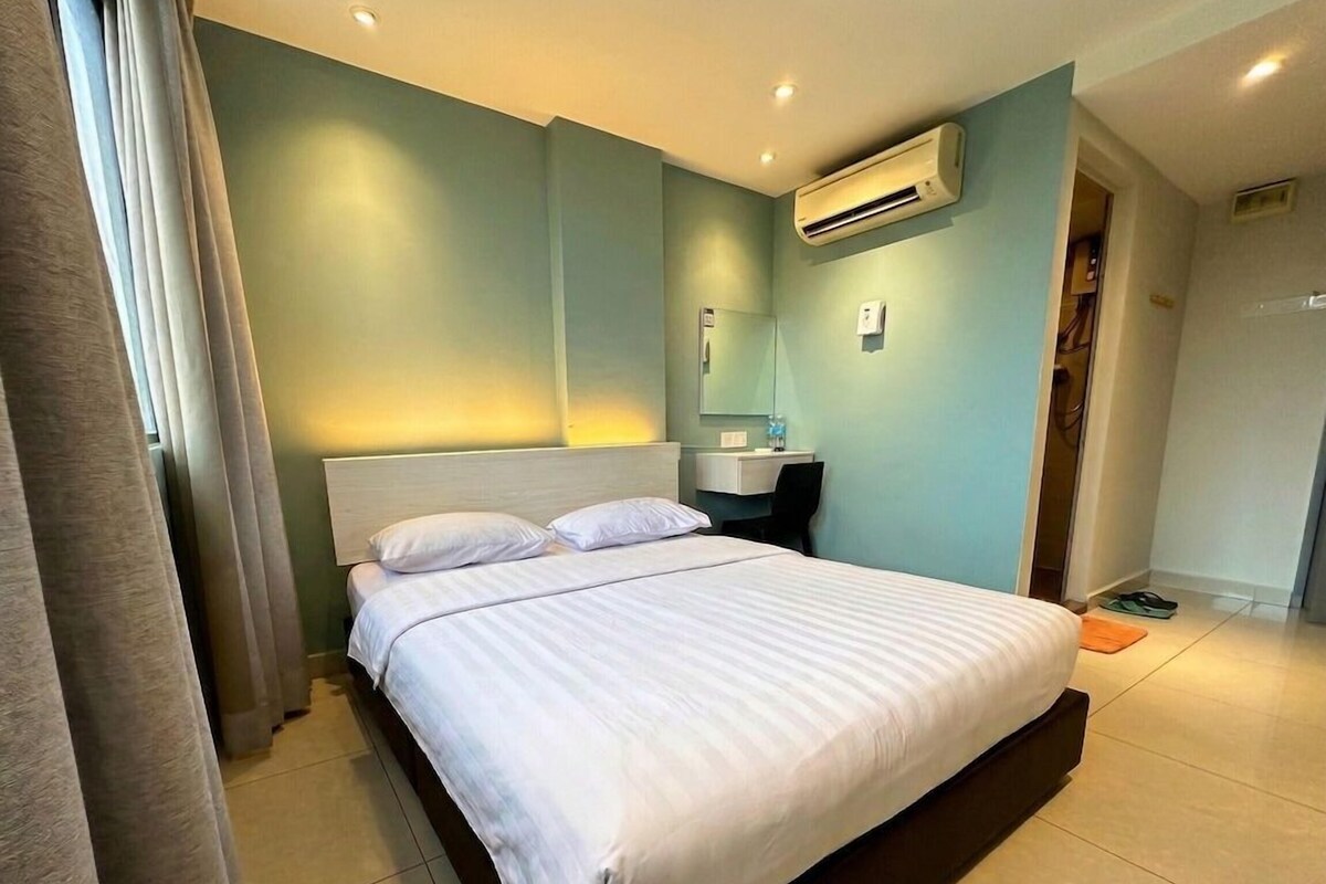 Une chambre d’hôtel équipée d’un lit, d’une table de chevet, d’un miroir et d’un appareil de climatisation.