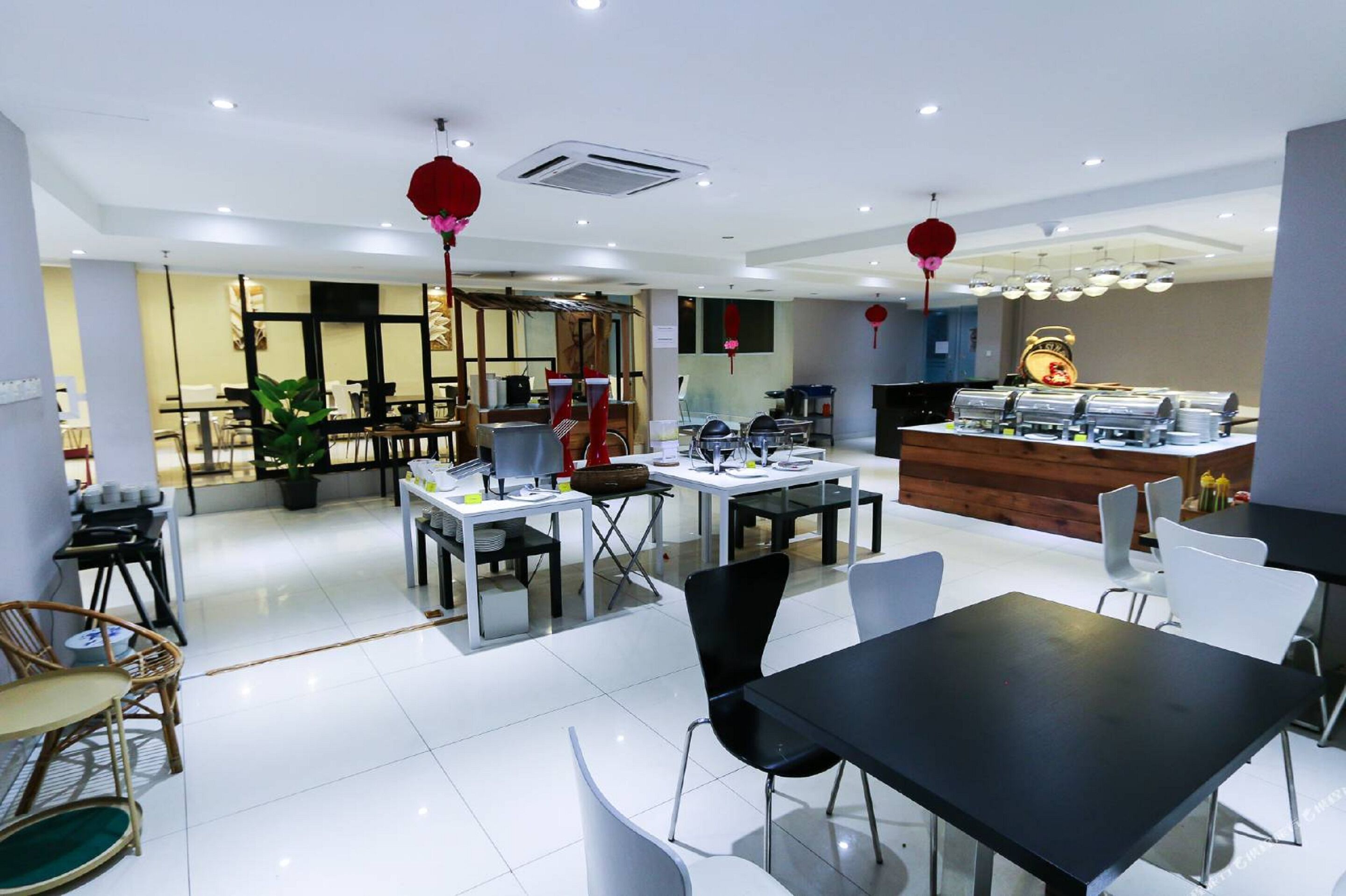 A modern restaurant with a central counter, multiple tables, and chairs.