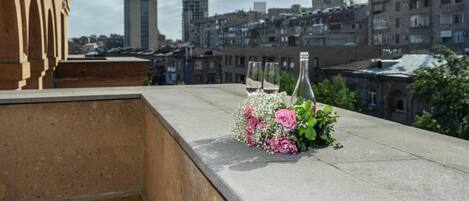 Terraza en la azotea con vistas a un paisaje urbano, que incluye una combinación de edificios residenciales y comerciales.